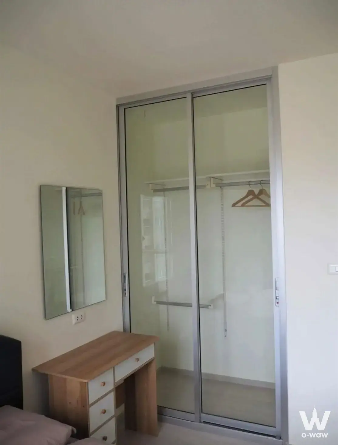 Modern bedroom with floor-to-ceiling frosted glass wardrobe and light wood vanity in 1-bed Aspire Sathorn-Taksin condo