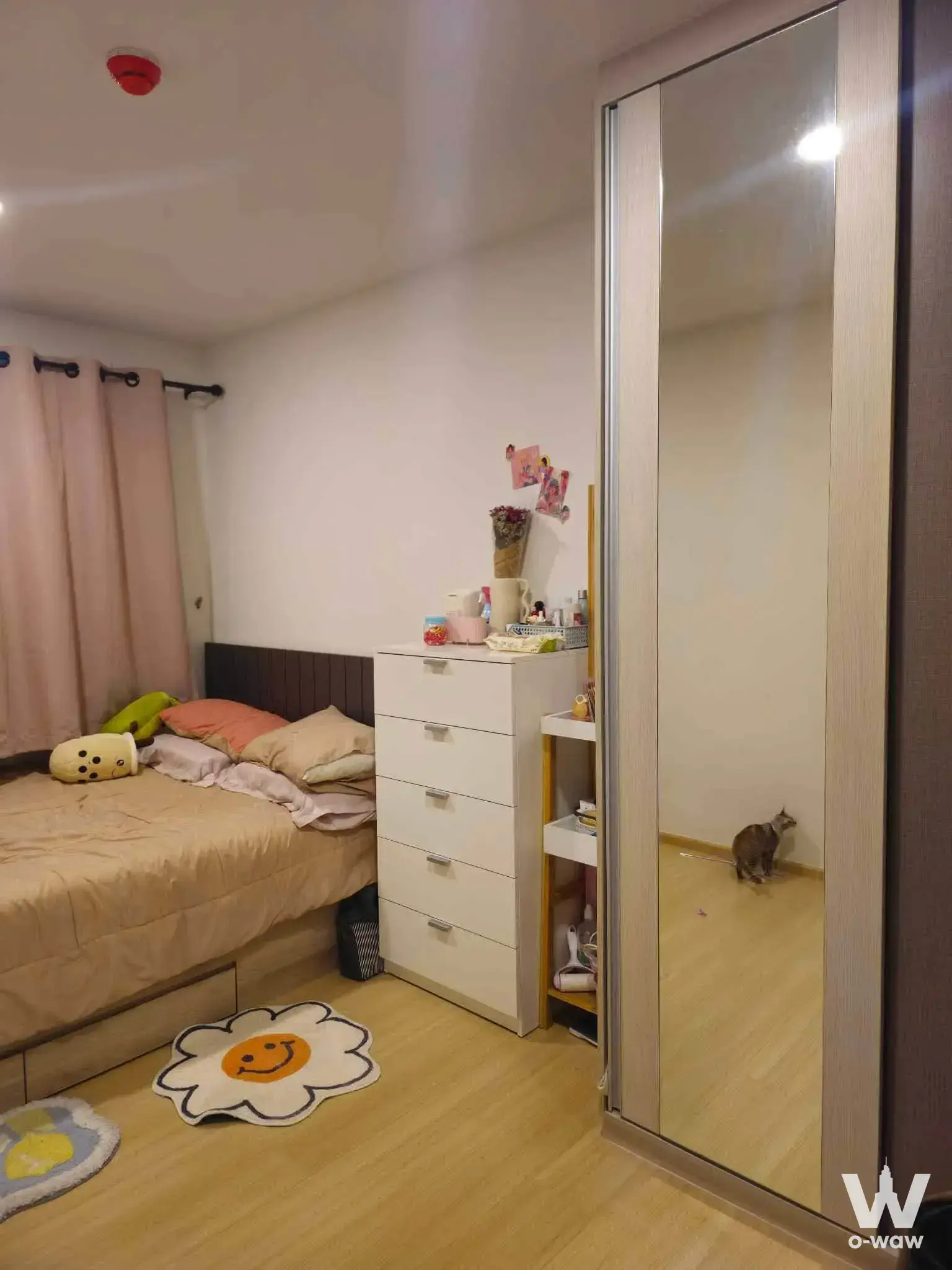Furnished bedroom in Chewathai Hallmark Ladprao condo with wood floors, wardrobe mirror, and cozy decor