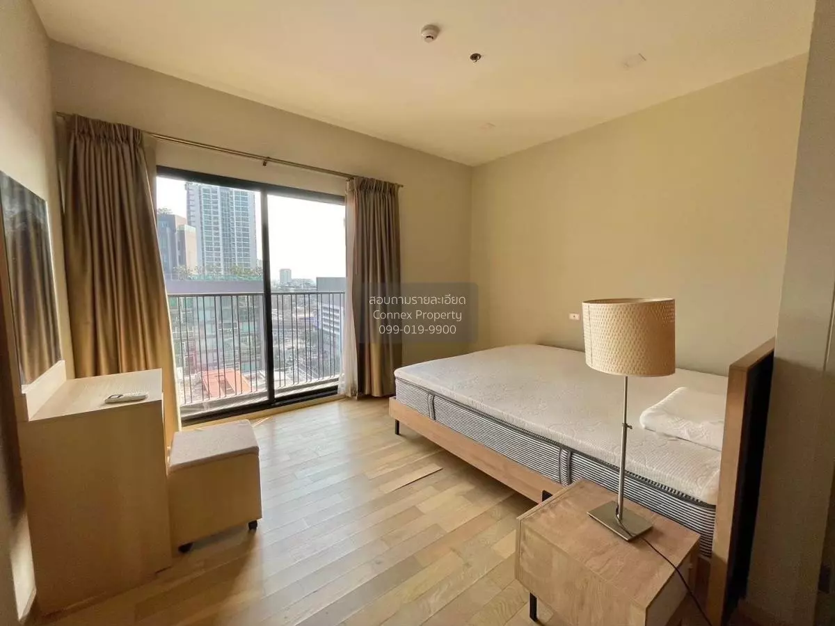 Modern bedroom in 1-bed condo for sale at Noble Reveal featuring city views and light wood accents