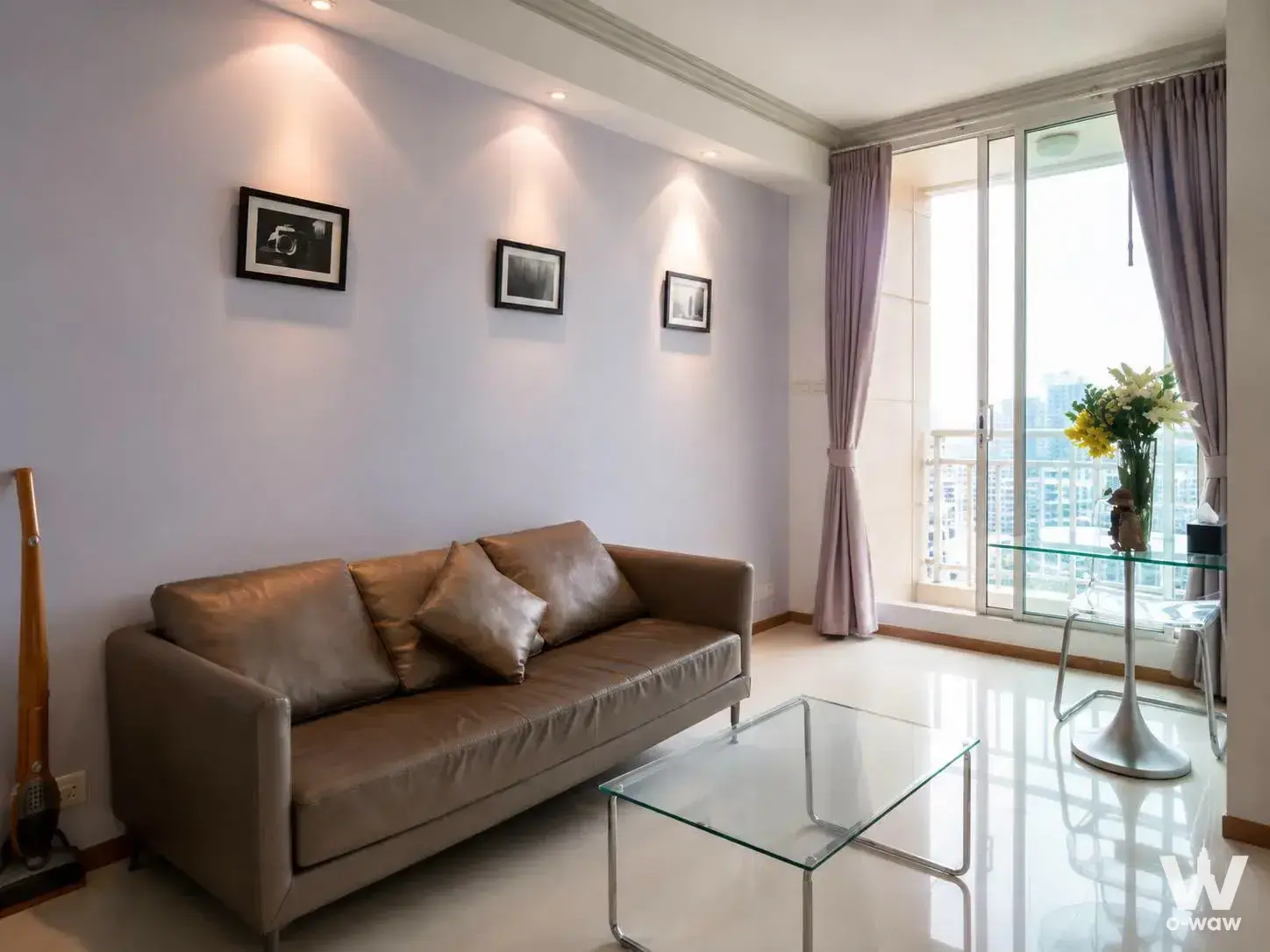 Living room in The Empire Place Sathon featuring taupe leather sofa and city skyline view