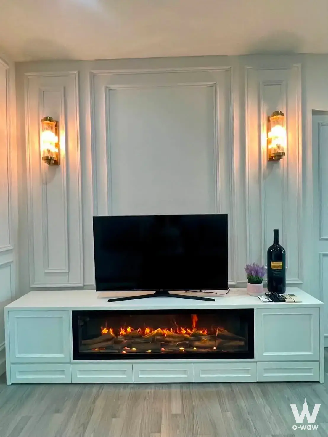 Modern living room with electric fireplace and grey wood flooring in The Room Wongwian Yai