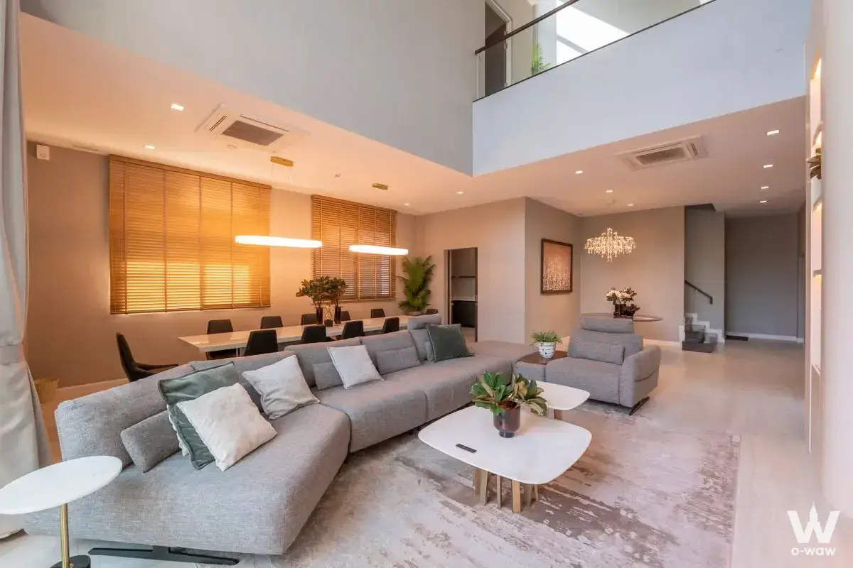 Spacious double-height living room with grey sectional sofa in 5-bed house for sale at The Gentry Phatthanakan 2