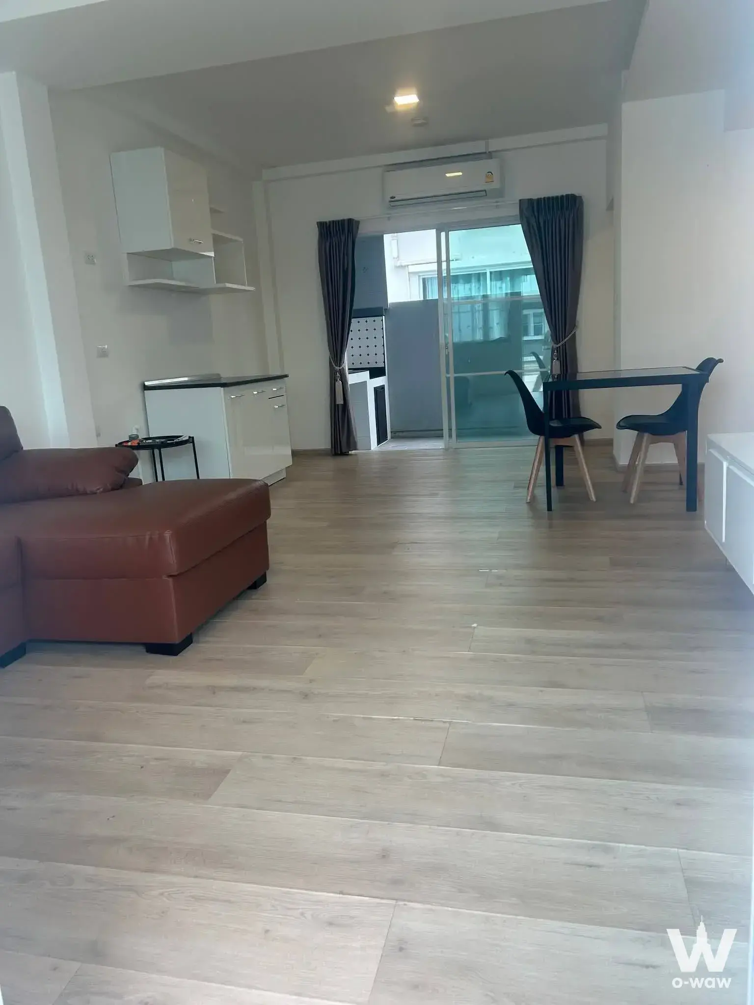 Open-plan living area in a 2-bed townhouse for sale in Indy 2 Bangna-Ramkhamhaeng 2 with leather sofa