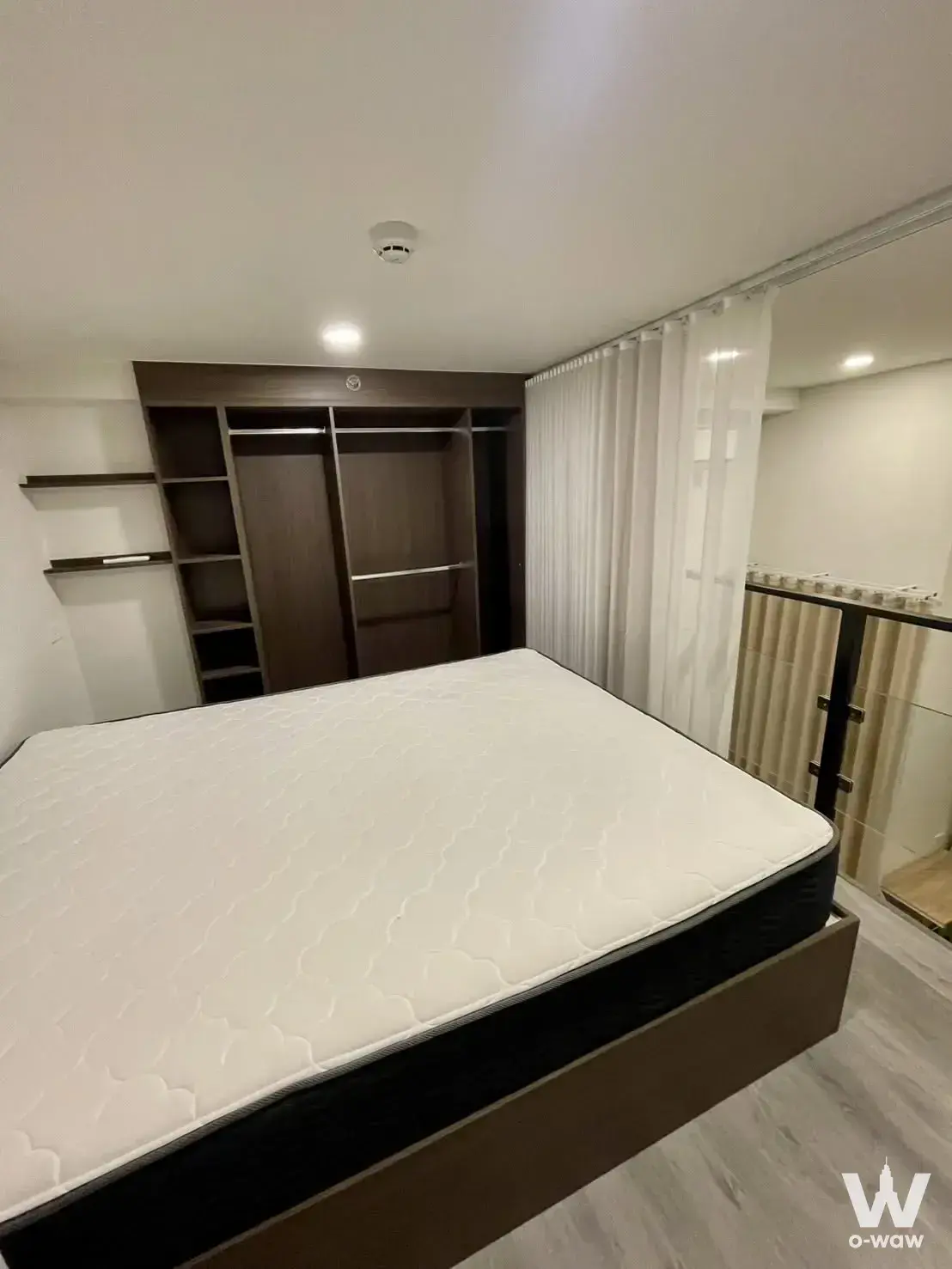 Unfurnished bedroom with queen bed frame, dark wood wardrobe, and balcony access in 1-bed rental at The Origin