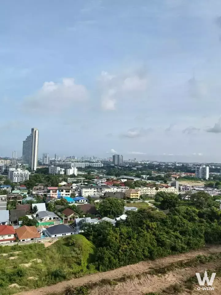 High-angle view from 1-bed condo for sale in Cetus Beachfront Pattaya showing lush trees and sprawling city skyline