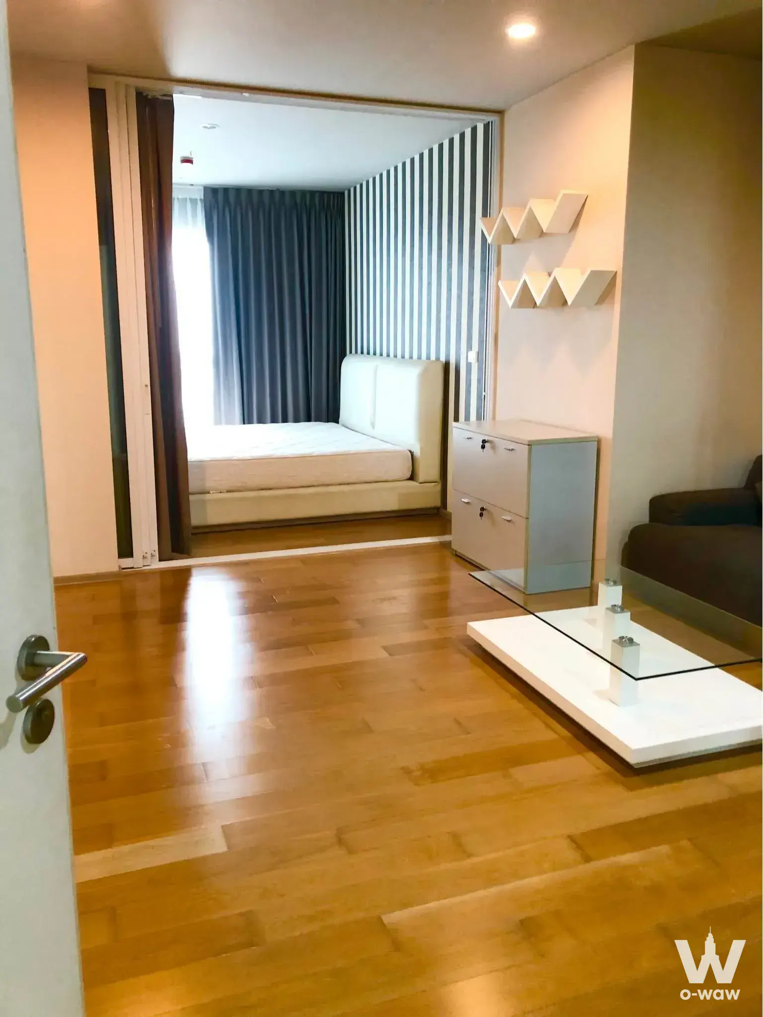 Hive Sathorn Condo bedroom with striped accent wall and natural daylight