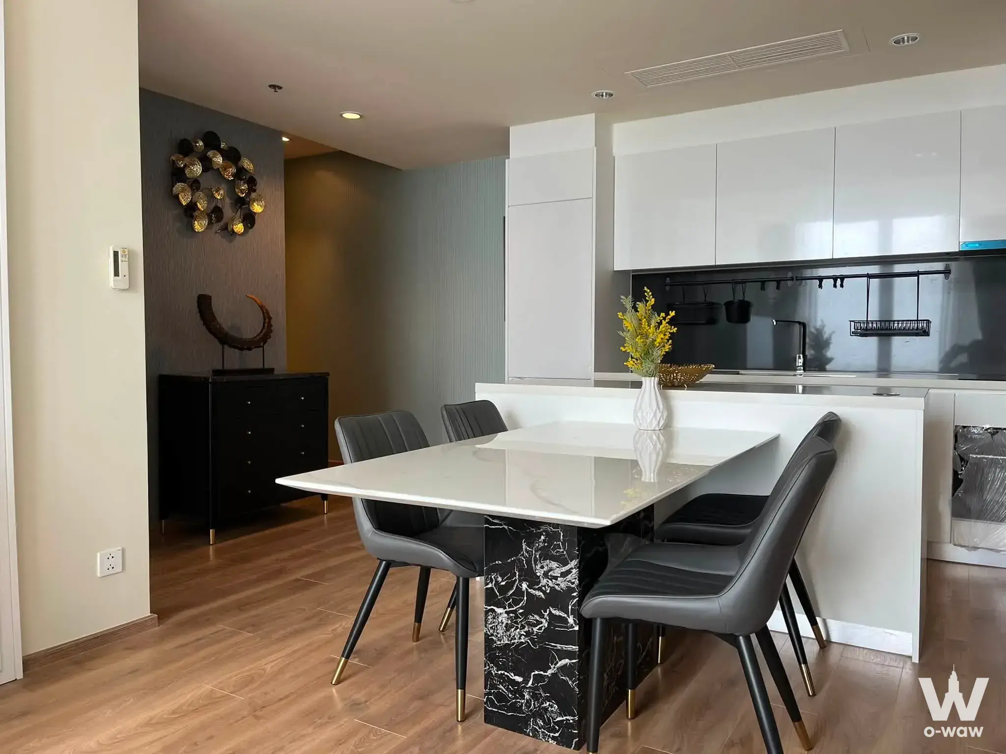 Modern dining area in 2-bed condo for rent at Noble Form Thonglor with marble table and open kitchen
