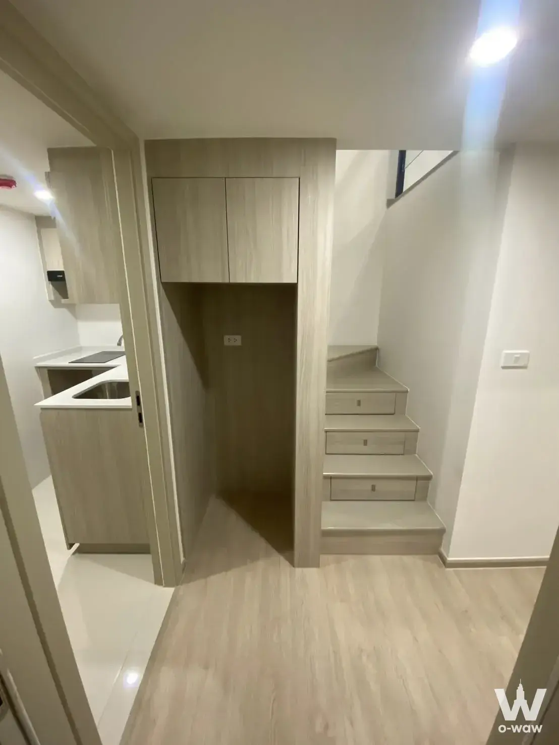 Duplex corridor in a 1-bed condo for sale at Origin Plug & Play E22 Station with light-oak stairs and cabinetry