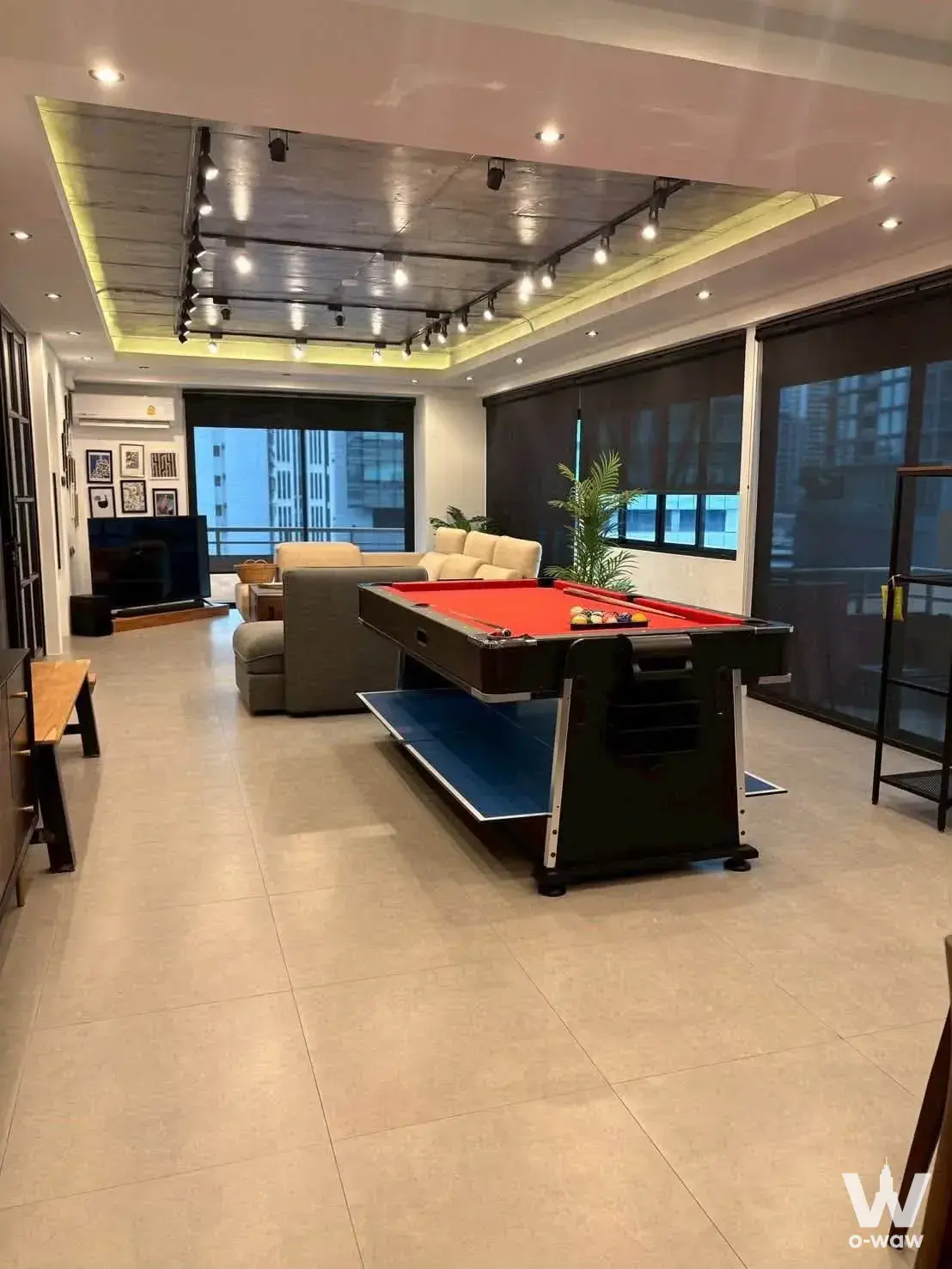 Game room with convertible pool table, sectional sofa, and city views in 2-bed condo for sale at Saranjai Mansion