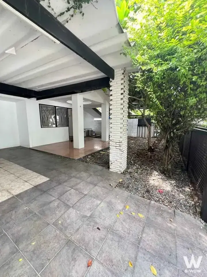Sammakon Village 3-bed house exterior covered patio with grey tile floor and large green tree