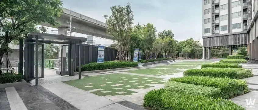 Modern condo courtyard entrance with guard booth and manicured hedges at ASPIRE Sathorn-Ratchaphruek 2-bed for sale