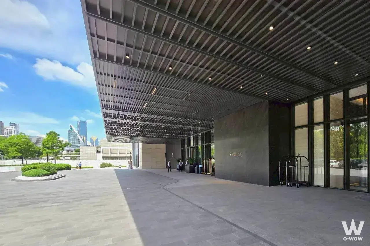 Modern porte-cochère with dark slat canopy and glass lobby entrance at One Bangkok 3-bed rental