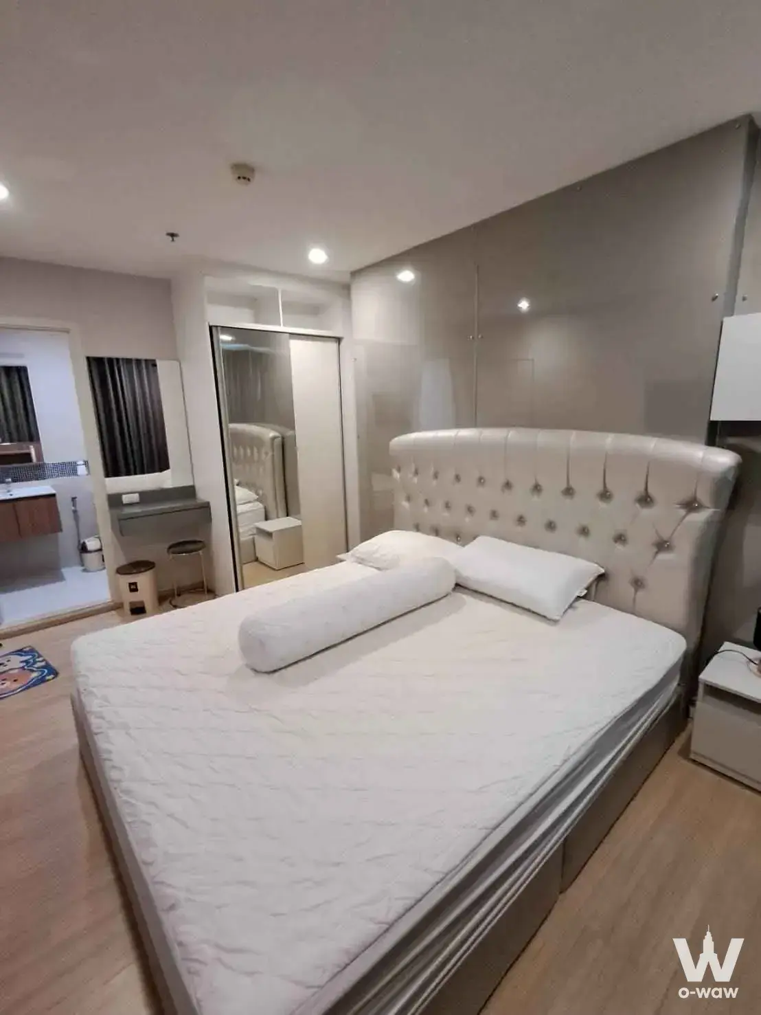 Modern bedroom in 2-bed Fuse Sense Bangkae rental with tufted headboard, vanity, and en-suite access