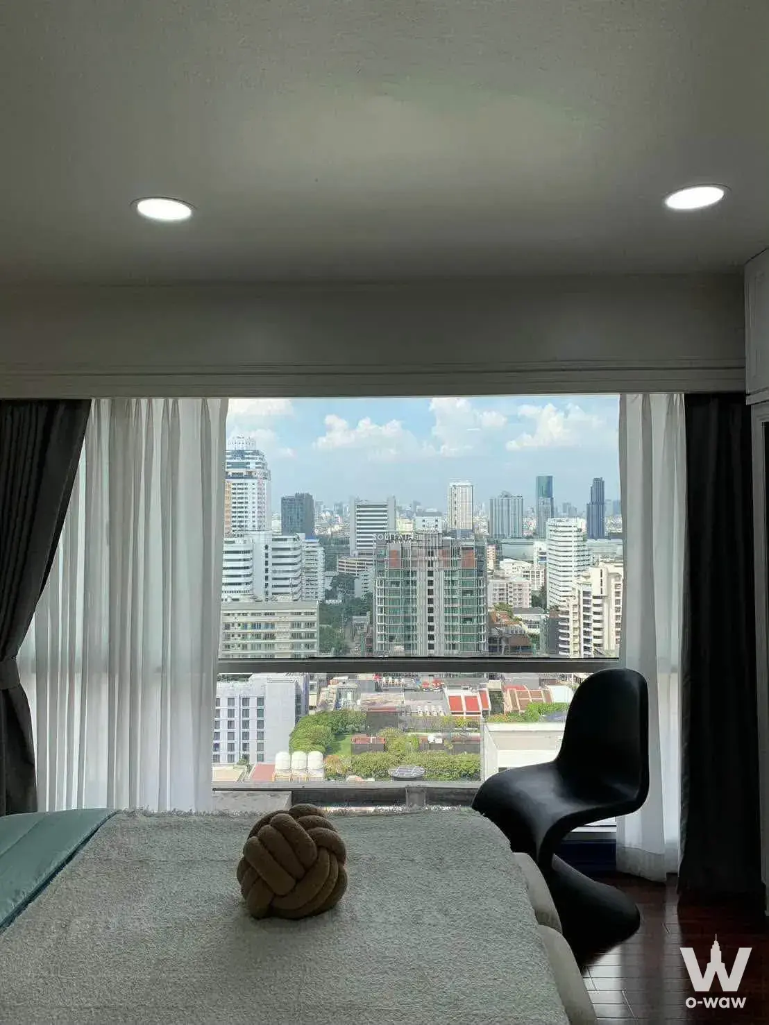 Modern bedroom with floor-to-ceiling windows overlooking Bangkok skyline in Lumpini Suite Sukhumvit 41 condo for sale
