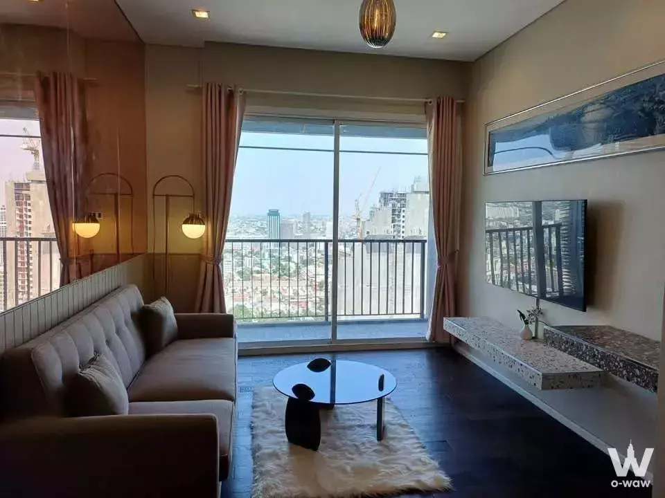 Modern living room in 2-bed condo for rent at The Saint Residences with sectional sofa and city view