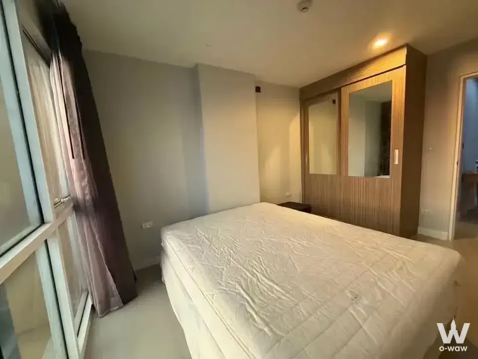 Bedroom in The Series Udomsuk with grey walls, queen bed and mirrored sliding wardrobe