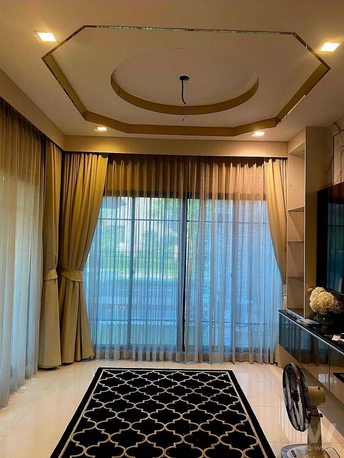 Modern living room in 4-bed Bangkok Boulevard Chaengwattana2 house for sale with cream tiles, gold tray ceiling, and dark