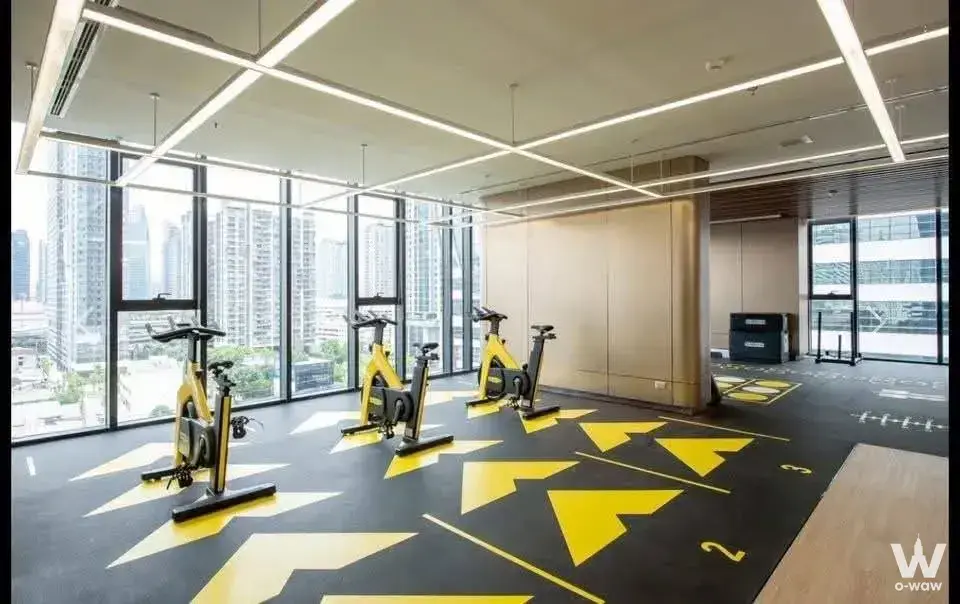 Gym in One9Five Asoke condo with yellow bikes and city views