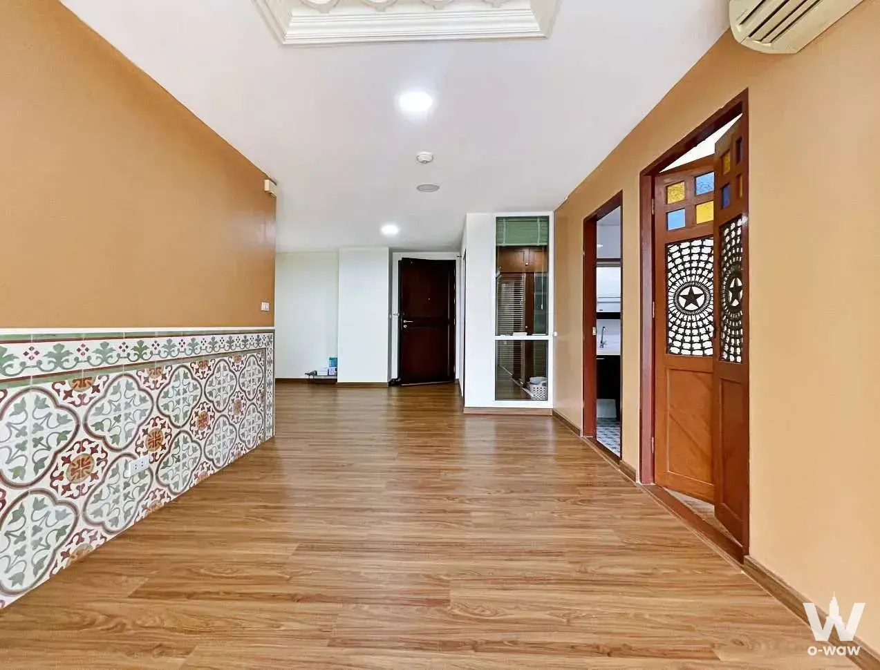 Empty corridor in a 2-bed condo for sale at The River Condominium with stained glass doors and floral tile wainscoting