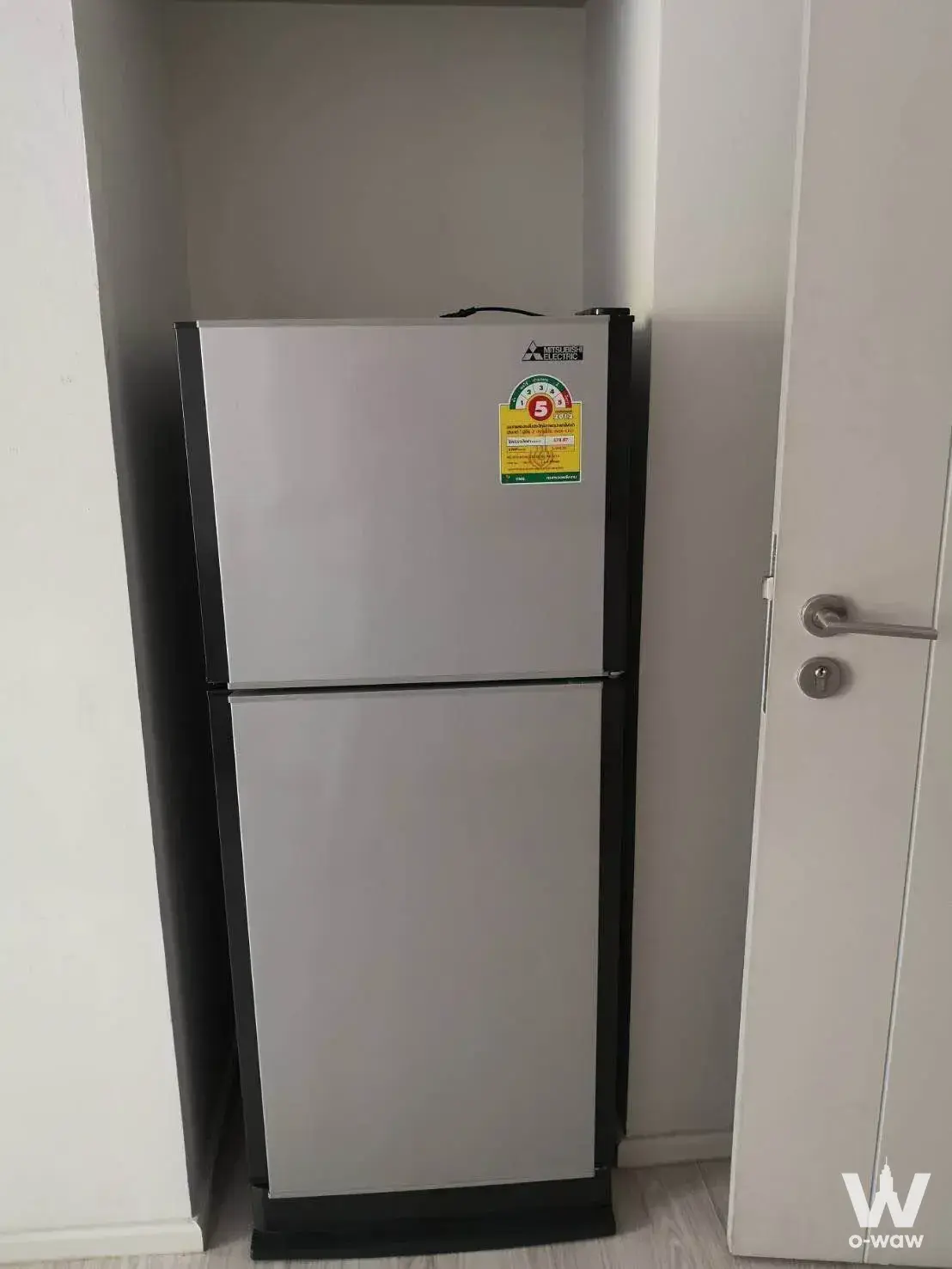 Compact kitchen nook in 1-bed condo for rent at M Ladprao featuring Mitsubishi fridge and light wood laminate flooring