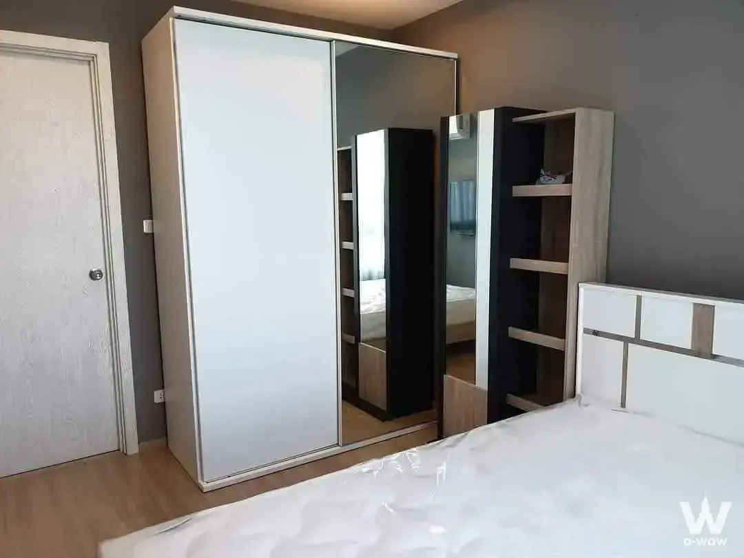 Modern bedroom in 1-bed Artemis Sukhumvit 77 condo with mirrored wardrobe and geometric headboard