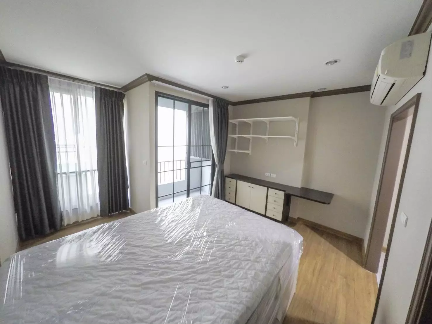 Unfurnished 1-bed condo bedroom in The Reserve Kasemsan 3 with study nook and balcony access