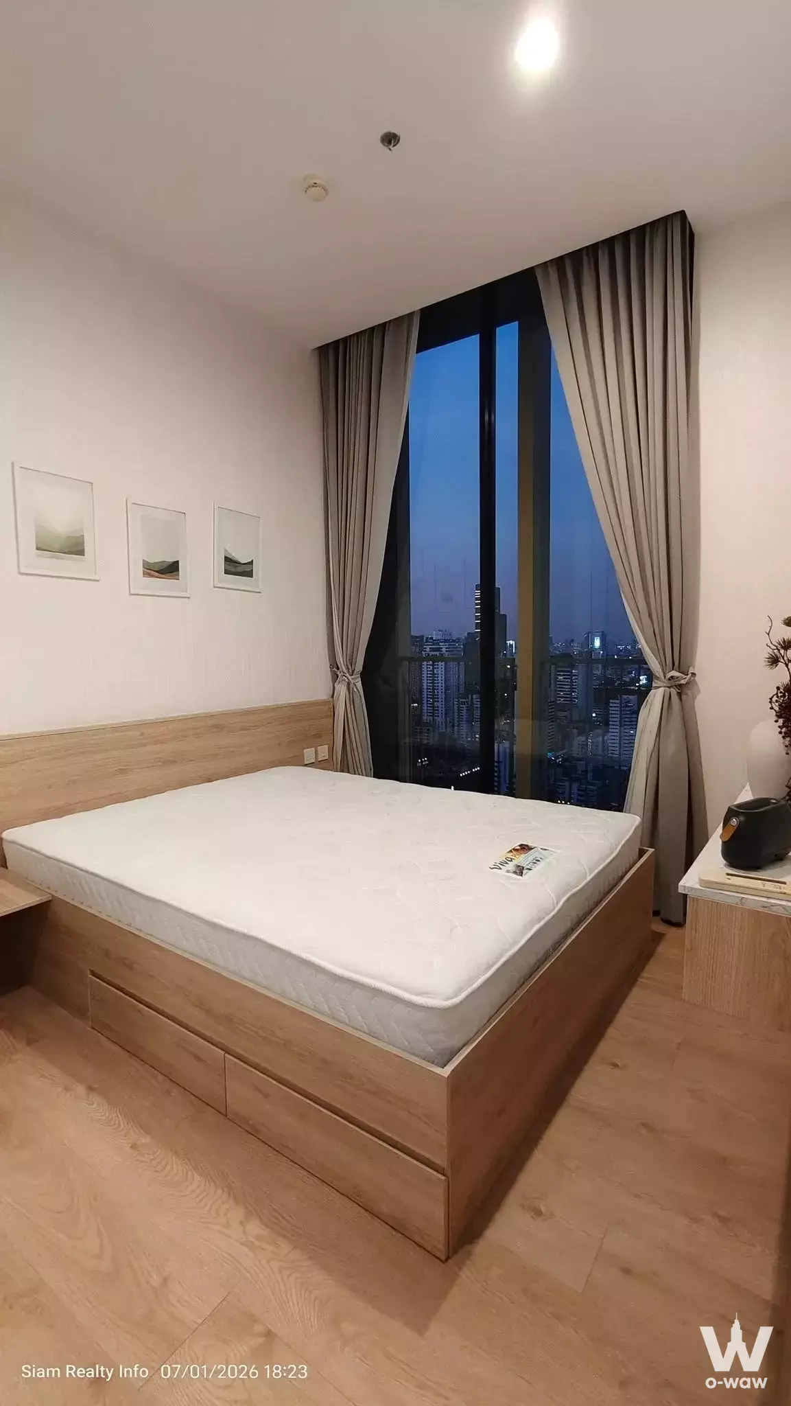Queen bed in 1-bed condo for rent at Noble BE19 with city skyline view from floor-to-ceiling windows