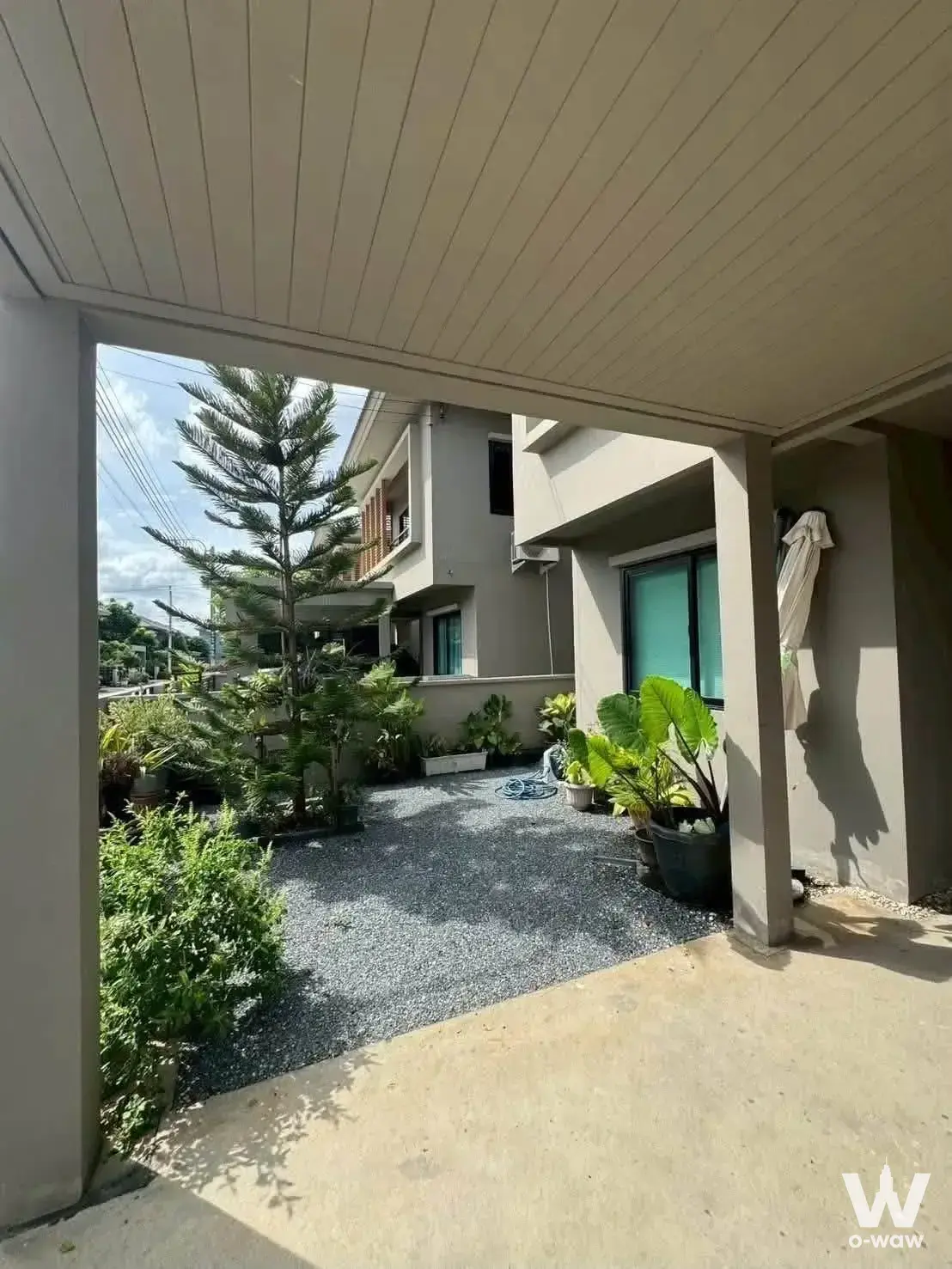 Covered carport and lush garden at a 3-bed house for rent in Como Botanica Bangna