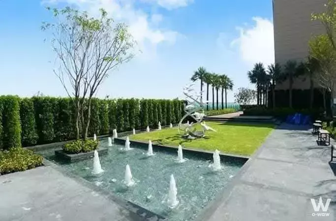 Rooftop garden with stone fountain jets and lawn at Life Sukhumvit 62 condo rental