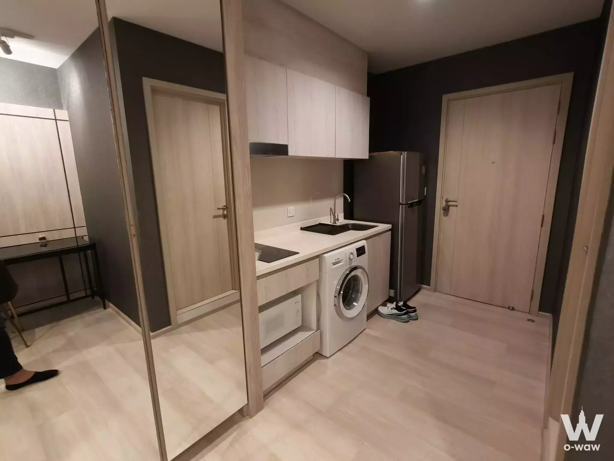 Modern 1-bed condo for rent in Life One Wireless with open kitchen, charcoal walls, and light wood floors