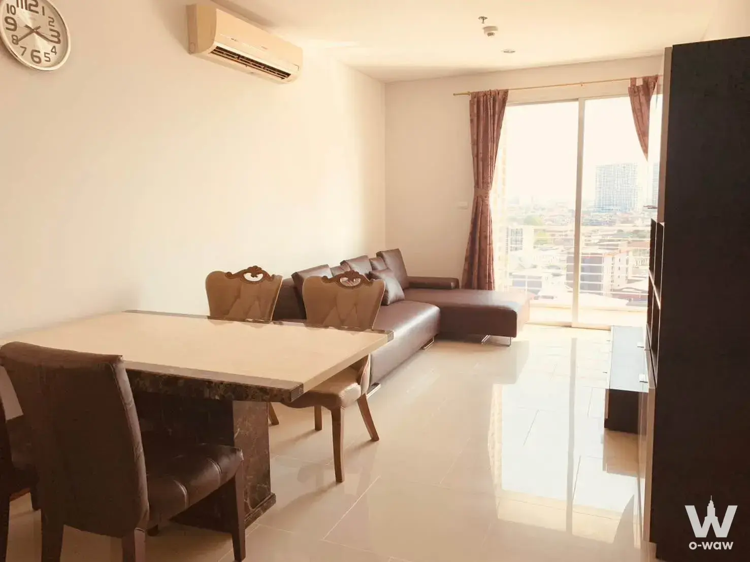 Living and dining area in Villa Sathorn with sectional sofa and city views