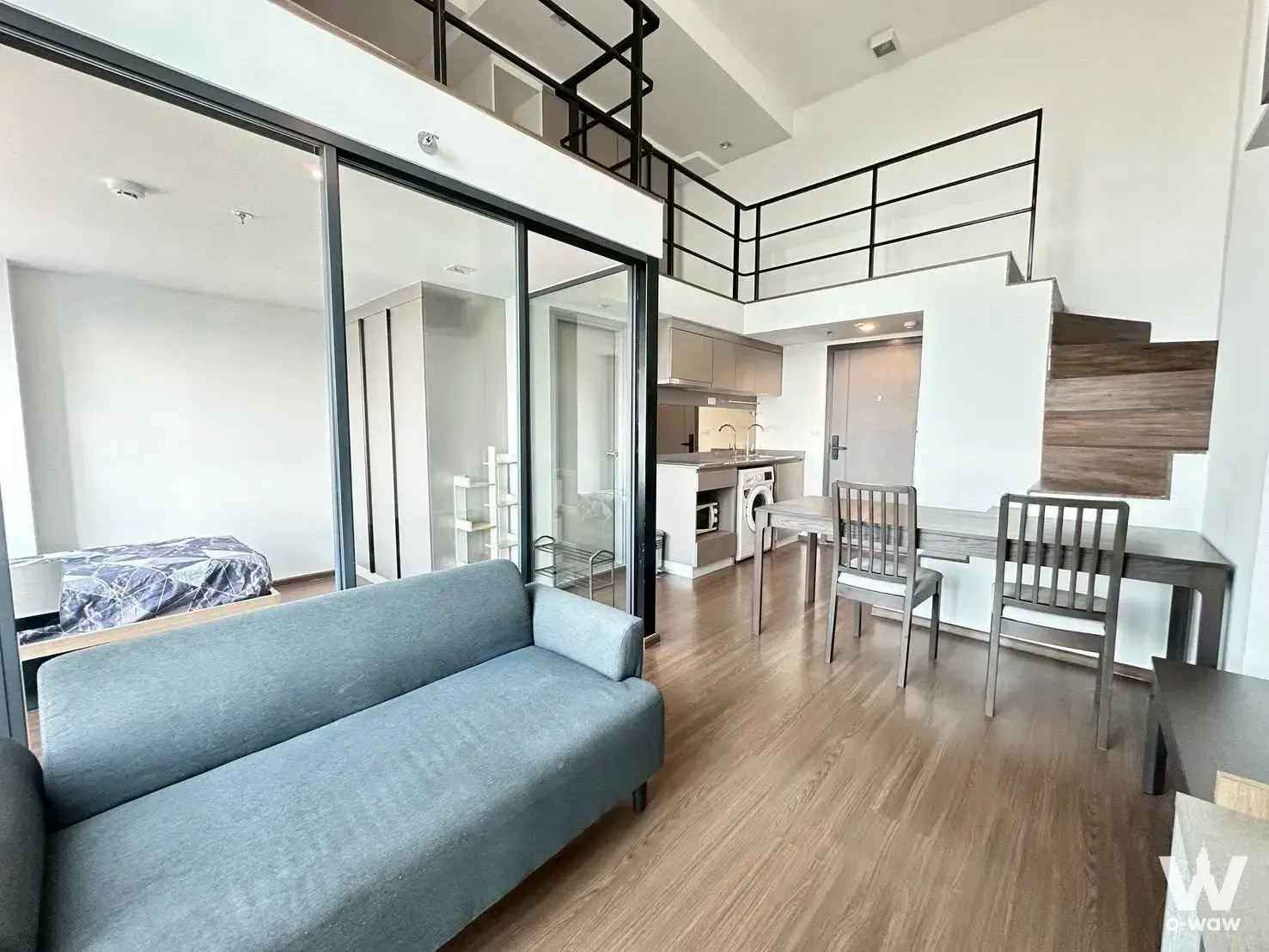 Modern 1-bed condo for rent in Ideo New Rama 9 with high ceilings, loft mezzanine, and open-plan living area