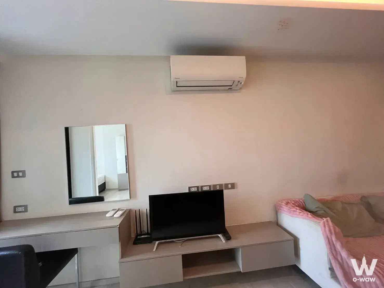 Tidy bedroom in a VTARA Sukhumvit 36 condo with a built-in desk, flat-screen TV, and light laminate flooring