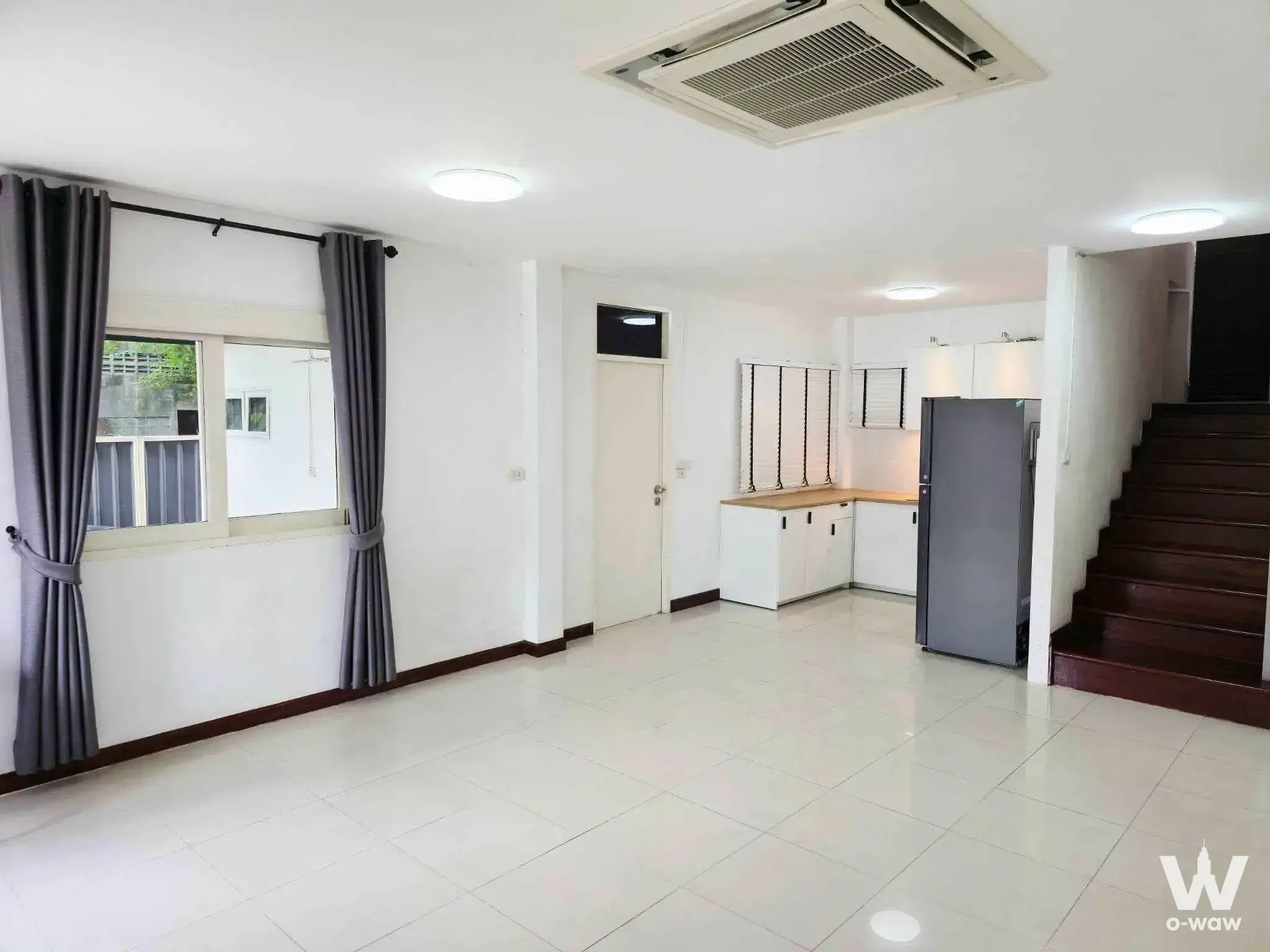 Nirvana@WORK 4-bed townhouse open-plan living area with glossy tiles, kitchenette, and staircase