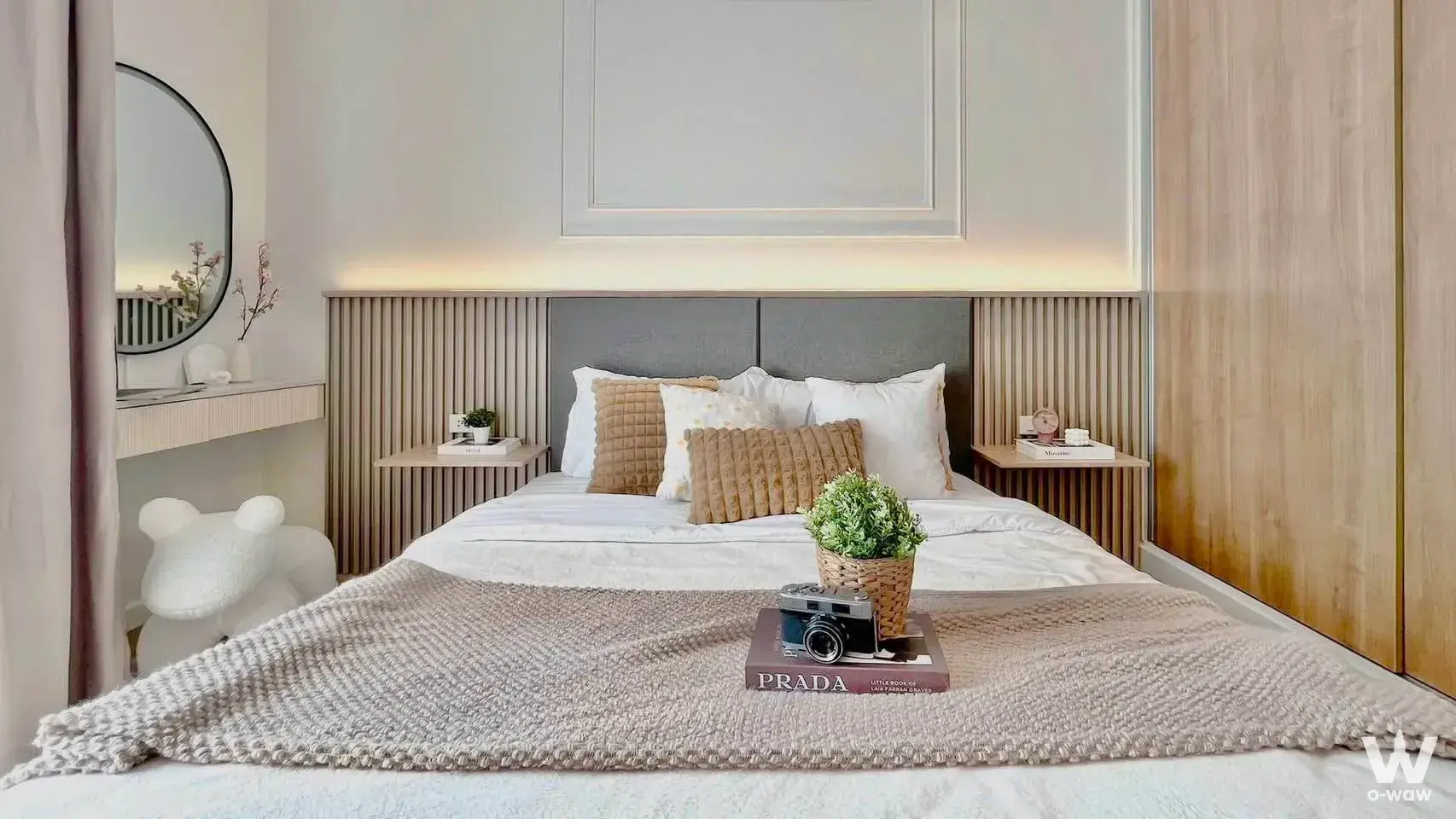 Master bedroom with textured beige throw, wood slat wall lighting, and floating vanity desk in The Iris Condo Rama 9
