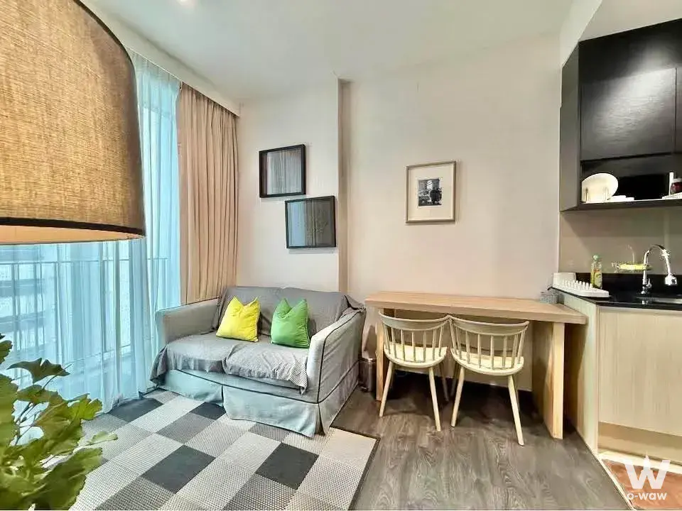 Modern 1-bed condo living room in The Edge Sukhumvit 23 with grey sofa and open kitchenette