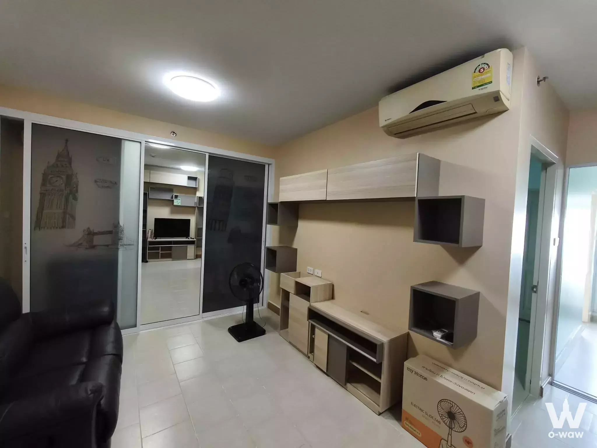Modern living room in 1-bed condo for sale at City Home Tha Phra with beige walls, white tiles, and London-themed wardrobe