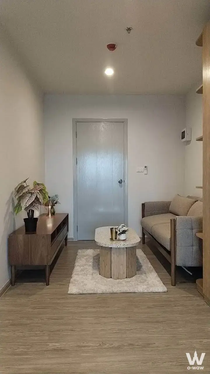 Compact living room at Regent Home Bangna with light-grey sofa walnut console and oval terrazzo coffee table