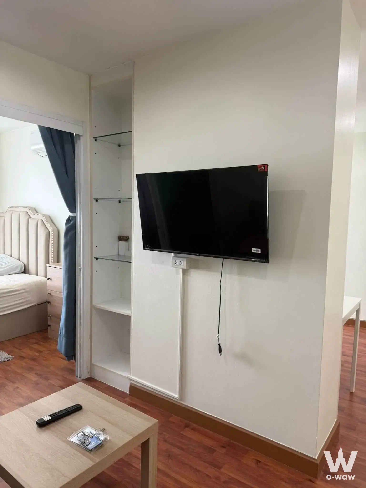 Furnished living room in Bangkok Horizon Ramkhamhaeng condo with wood table and TV
