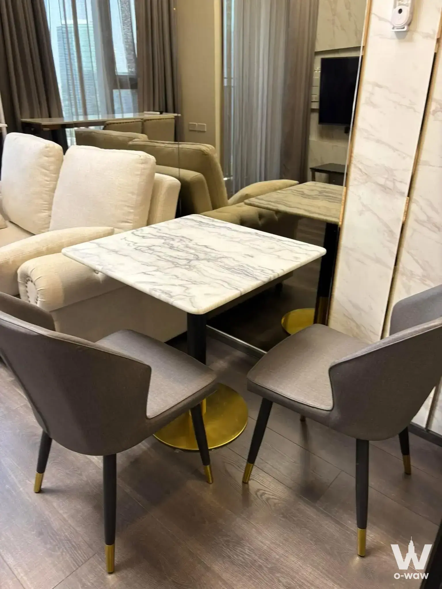 Furnished dining-living area in KnightsBridge Space Ratchayothin with marble table and gold accents