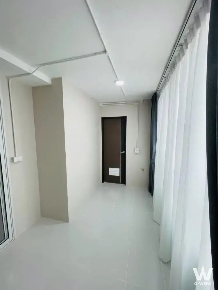 Unfurnished room in Happy Condo Rachada 18 with glossy white tiles and floor-to-ceiling windows