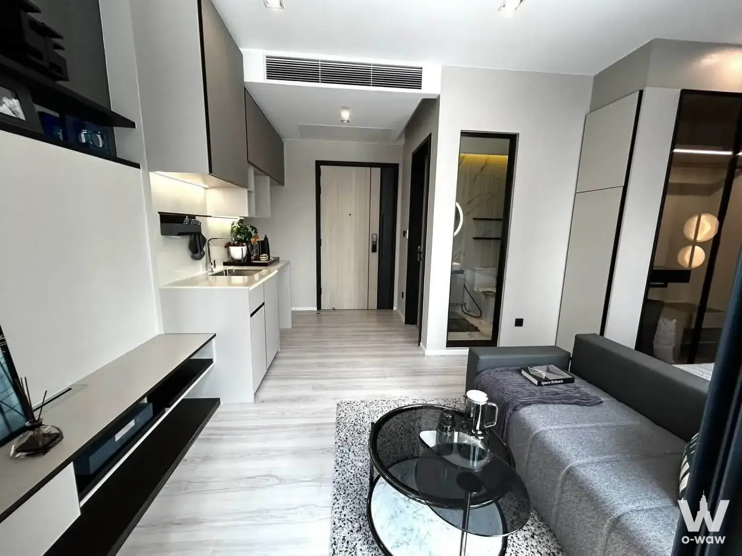 Open-plan living and kitchen in The Room Phaya Thai condo with neutral decor
