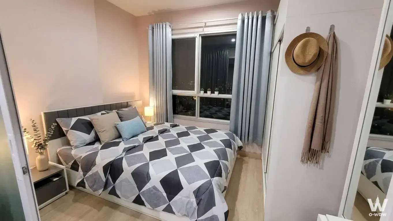Cozy bedroom in The Tempo Grand Sathon-Wutthakat condo with mirrored wardrobe and night city lights