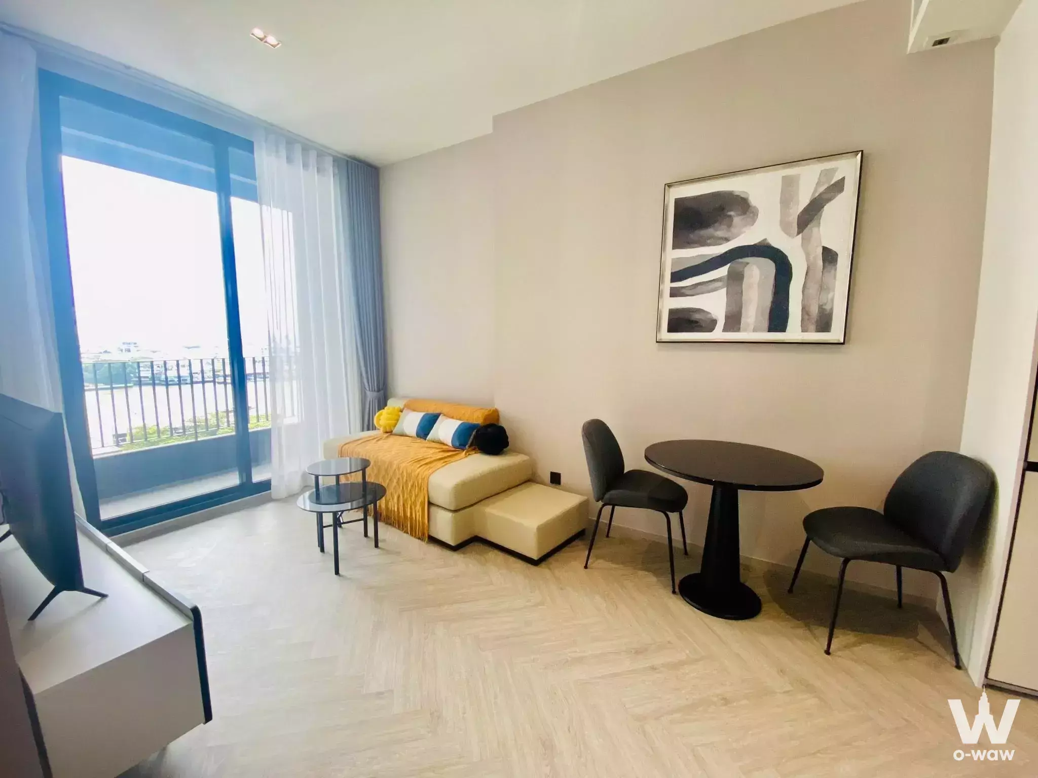 Furnished living and dining area in 2-bed condo for sale at Chapter Charoennakhon Riverside with balcony access