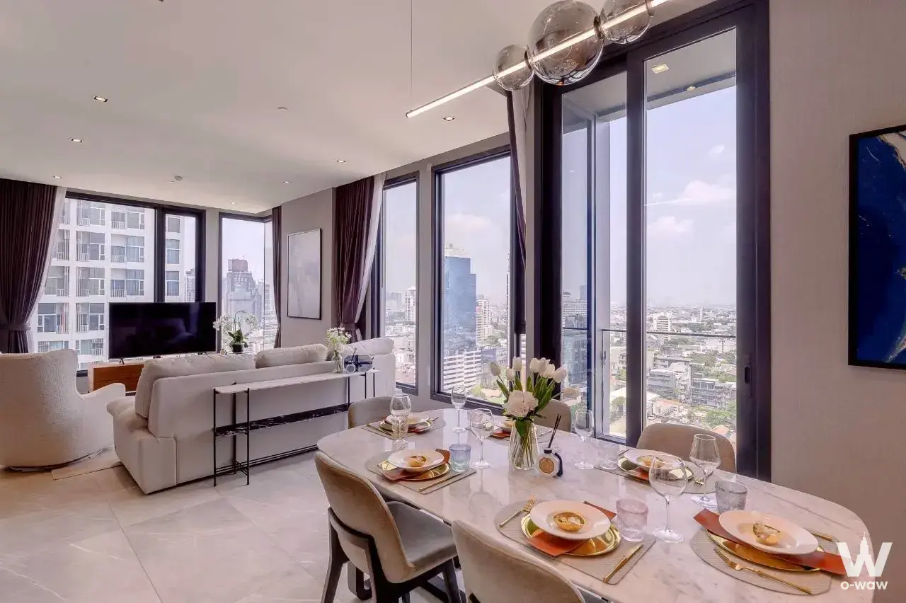 Modern 1-bed condo living room in Life Asoke Rama 9 with city views, marble dining table, and sectional sofa