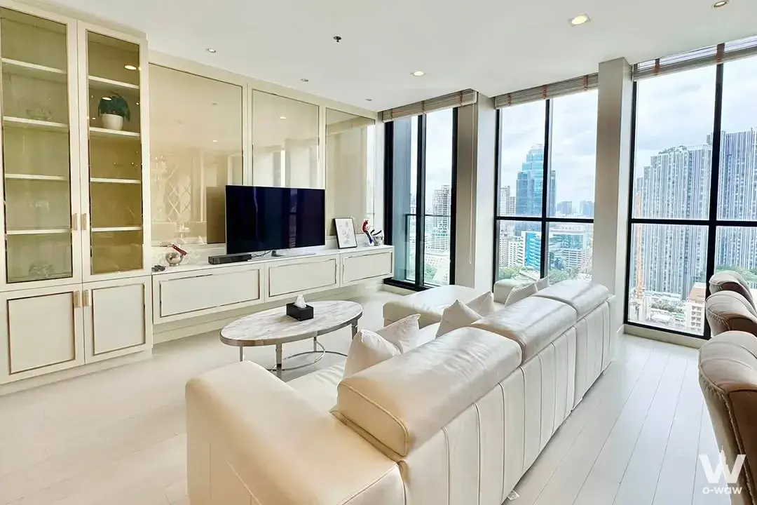 Luxury living room in Noble Ploenchit featuring a cream leather sectional sofa and floor-to-ceiling city views
