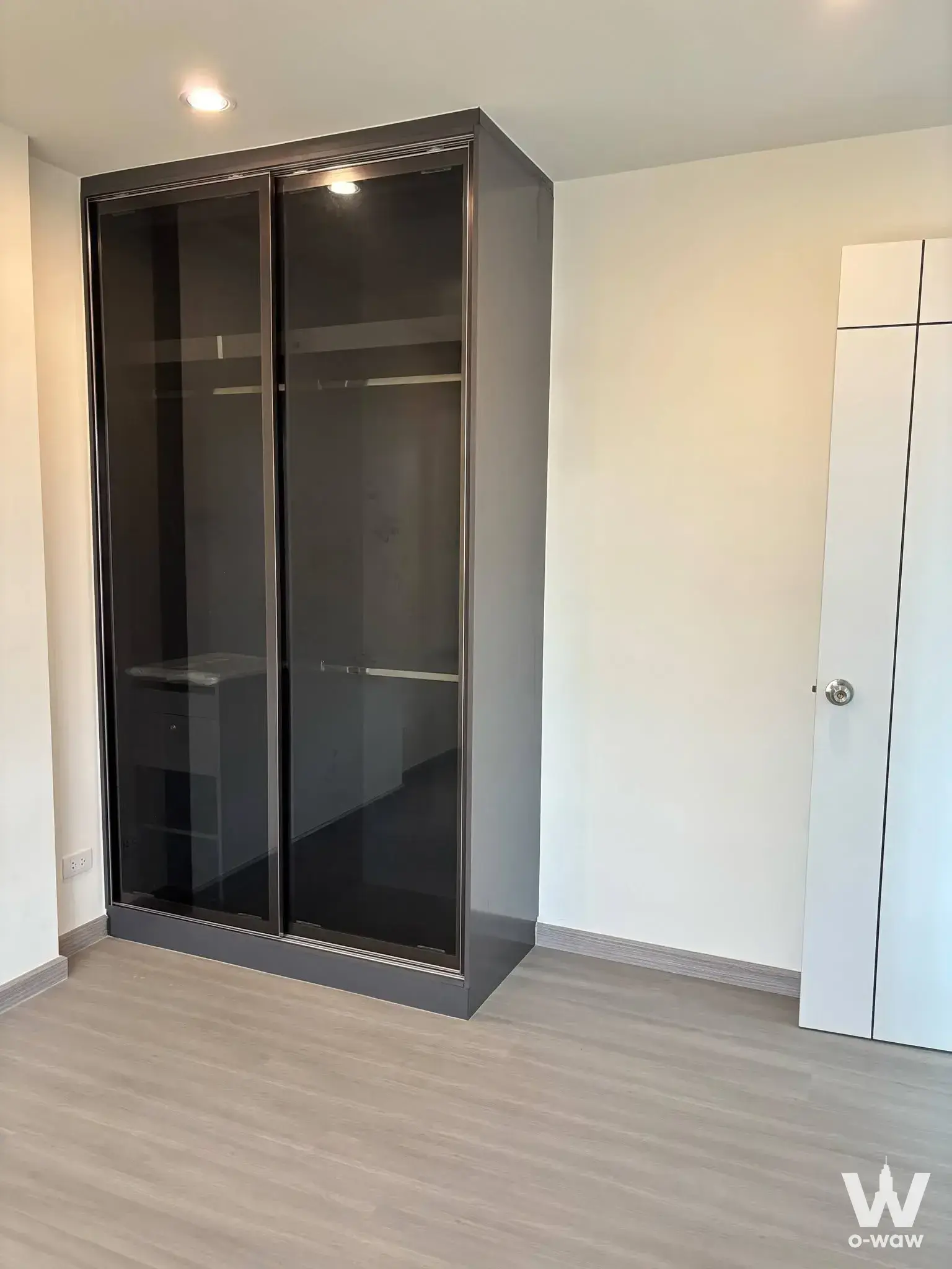 Unfurnished bedroom in 1-bed condo for sale at The Station Condo featuring grey laminate floors and large wardrobe