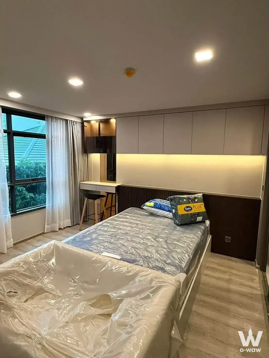 New bedroom in Maestro 19 Ratchada19 featuring built-in storage and a window with green views