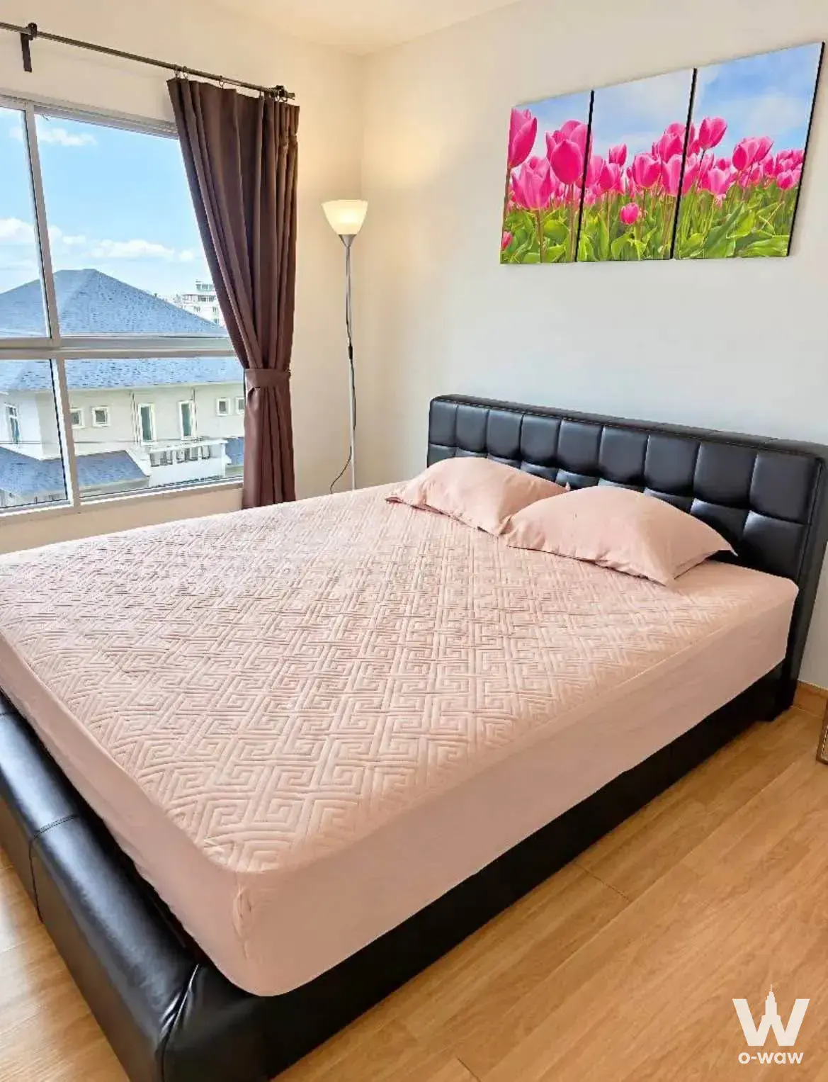 Pink-accented bedroom in S&S Sukhumvit condo with tulip art and bright daylight