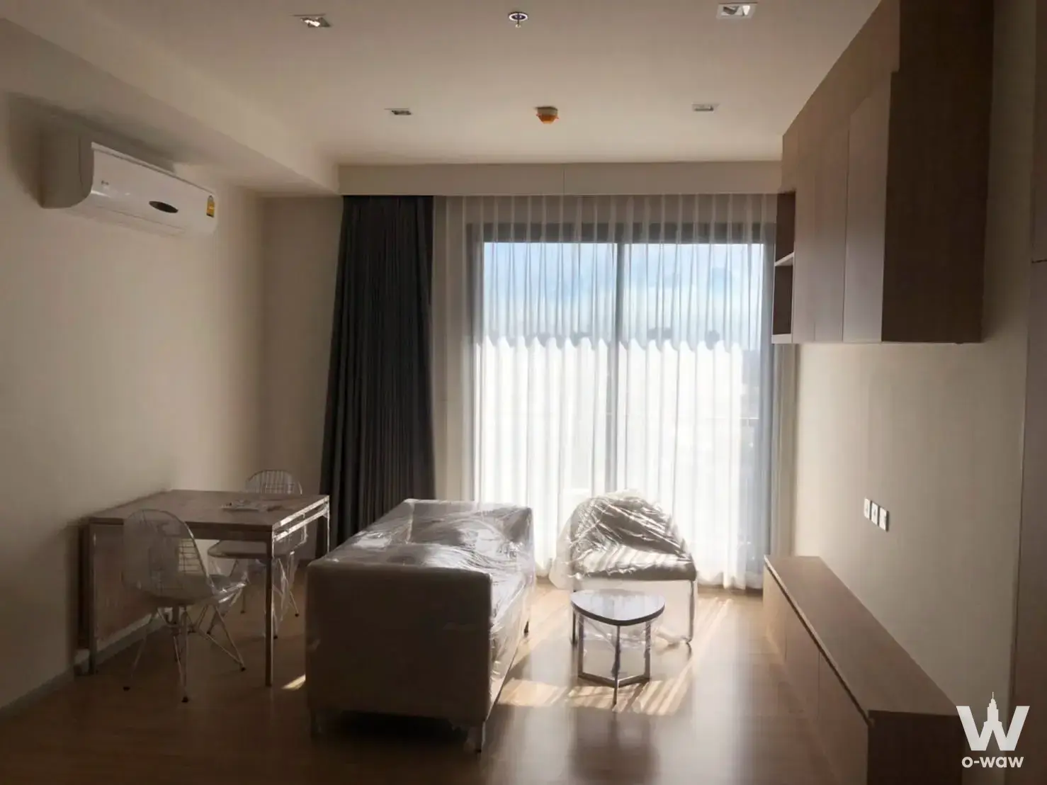 Modern 2-bed condo living room in M Jatujak with light wood floors and city view
